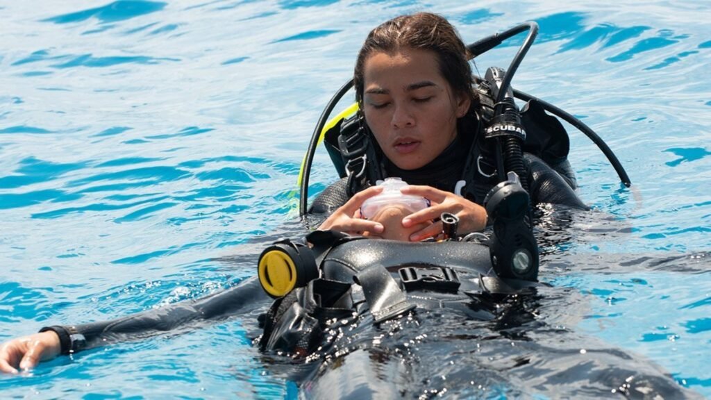 Scuba diver performing a rescue technique on a fellow diver at the water surface